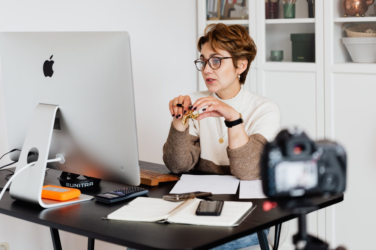 Confident elegant lady in eyeglasses hosting webinar